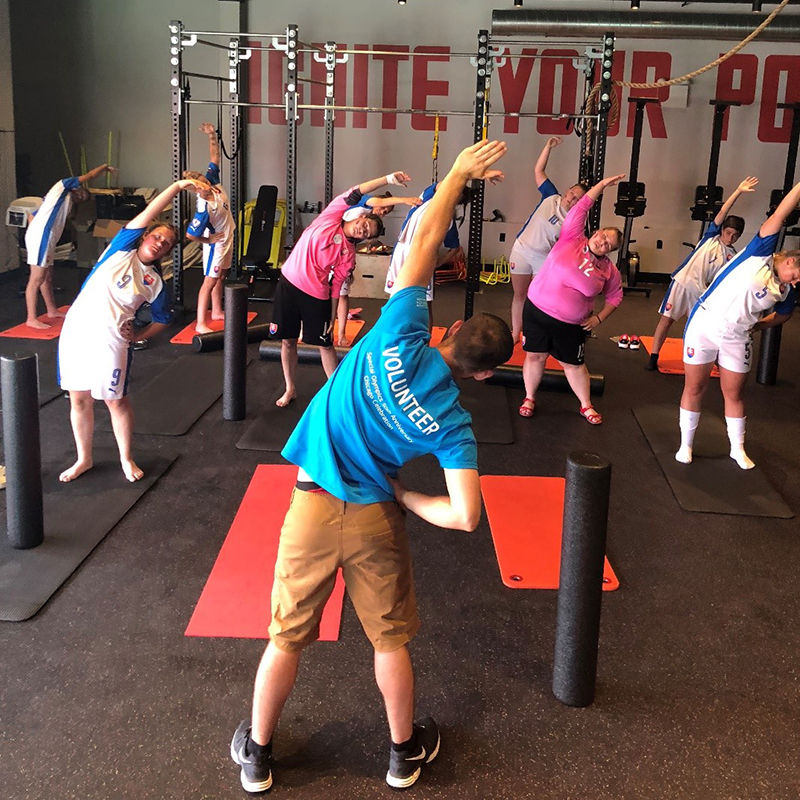Volunteer demonstrating a movement while athletes follow along